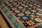 Detail view of navy blue field with saffron yellow palmettes and emerald green border.