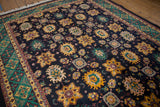 Navy field with saffron palmettes, emerald green motifs, and a shield-like trefoil border.