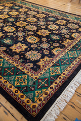 Corner detail of vintage Agra carpet, emerald green trefoil border, saffron yellow blossoms, and fringe.