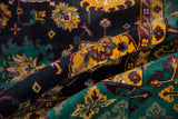 Full pile texture on a vintage Agra rug, displaying saffron, emerald, and navy floral motifs.