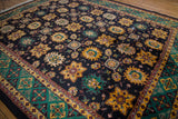 Vintage Agra carpet border showing emerald green shield-like trefoil blossoms and navy field.