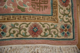 Vintage Japanese Peking carpet corner with rose field, green floral border, key motif, and fringe.