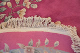 Curved ivory fringe, beige selvage, and pink hand-knotted reverse of the Art Deco rug.