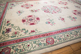 Vintage Peking rug border with pink, seafoam green floral elements and cloudbands.