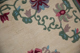 Vintage Japanese Peking rug's full ivory pile with green vines, pink, blue, and mauve blossoms.
