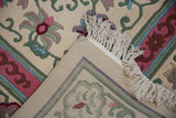 Vintage Japanese Peking carpet corner reveals pink, wine red floral motif, ivory fringe, and hand-knotted back.