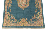 Corner of vintage Indian Aubusson carpet, sky blue field, blush floral motifs, light fringe.