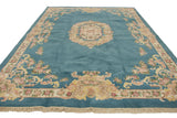 Fringed corner of sky blue Indian Aubusson design rug with blush and pale gold floral border.