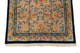 Indian Arts and Crafts rug corner, beige field, cobalt blue border, gold blossoms, tinted fringe.