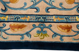 Curvilinear cobalt blue vinery and saffron buds on beige field, with dark blue border.
