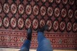 View from above showing the plush texture and detailed gul pattern of a fine Bokhara carpet.