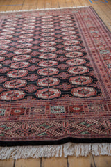 Angled view of a fine Bokhara carpet showing its lustrous pile and repeating gul medallions.