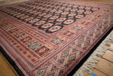 Lustrous wool pile of a vintage Bokhara carpet showing its intricate geometric border and ivory fringe.