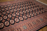 Repeating rust gul medallions and an elaborate geometric border on a fine vintage Bokhara carpet.