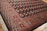 Plush wool pile, intricate geometric border, and intact selvage of a vintage Bokhara carpet.