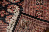 A vintage Bokhara carpet corner folded to reveal the plush wool pile and tight weave.