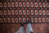 The tight, fine weave and plush pile of a Bokhara carpet with repeating geometric gul medallions.