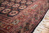 Lustrous, plush pile and intricate geometric border on a fine hand-knotted Bokhara rug.