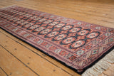Fine vintage Bokhara runner laid diagonally, showing its lustrous wool and repeating gul medallions.