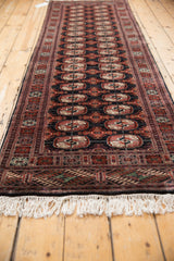 A low angle highlights the repeating gul medallions on a vintage Bokhara rug runner.