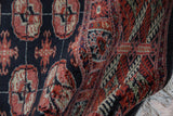 Plush, high-sheen wool pile of vintage Bokhara rug, brick red, ivory, and navy gul medallions.