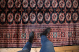 A view from above showing the fine wool pile and intricate border of a Bokhara carpet.