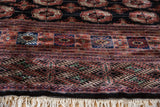 Intricate geometric border and plush wool pile of a vintage Bokhara carpet with ivory fringe.