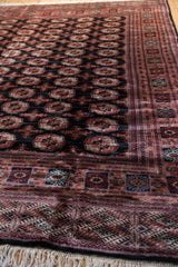 Lustrous wool pile and intricate border at the corner of a fine Bokhara carpet.