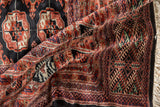 Draped Bokhara carpet showing plush wool, detailed borders, and gul medallions.