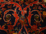 Fine weave showing scrolling rose motifs in madder red and gold on a dense, navy blue pile.