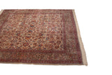 Ivory Kerman carpet with curvilinear vine arabesque border and floral palmettes.