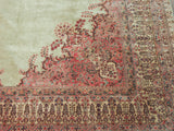 Vintage Kerman carpet corner: blush and rose millefleur spandrel on pale seafoam green field.