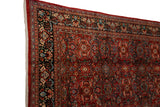 Corner view of a vintage Mahal carpet's lush pile and expressive floral serrated leaf motif.