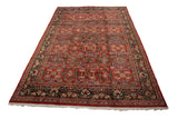 Angled view of a vintage Persian Mahal carpet showing the brick red field and its detailed floral design motif.