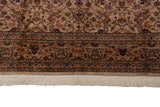 Close view of the intricate floral border, plush wool pile, and ivory fringe of a vintage Pakistani carpet.