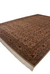 Angled view of a vintage Pakistani Isfahan carpet showing the lustrous floral pattern and ivory fringe.