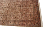 Corner detail of a vintage Pakistani carpet showing the intricate floral border and clean ivory fringe.