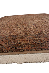 Angled perspective across the dense, lustrous wool pile of a vintage carpet, showing the floral border and ivory fringe.