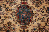 Detailed blue and rose medallion on the plush ivory pile of a vintage Kerman carpet.