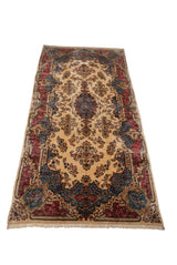 Angled perspective showcasing the vintage Kerman carpet's full length and floral design.