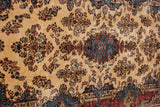 Angled view of a vintage Kerman carpet, showing its plush pile and intricate floral spray design.
