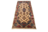 Angled view of a vintage Kerman carpet with intricate floral sprays and a Rococo style border.