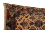 Draped view of a Persian Kerman carpet highlighting the intricate red and blue stepped border.