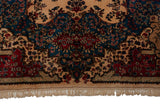 Ivory fringe and plush, stepped floral border of a vintage Persian Kerman carpet.