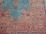 Vintage Kerman carpet corner showcasing blush and cochineal red thousand flower border.