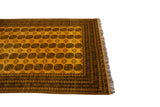 Saffron yellow field with charcoal elephant's footprint gul motifs, geometric border, and fringe.