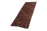 Angled view of a collector's antique Beshir carpet showing its geometric multi-panel design.