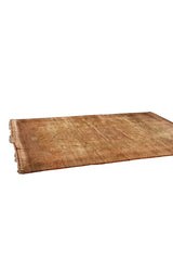 Angled view of an antique Persian Tabriz showing the green floral field and red side cord.