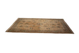 Vintage Japanese Peking carpet viewed from an angle, showing its floral medallions on a coffee brown field.