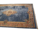 Corner of Japanese Savonnerie rug featuring scrolling border, rose bouquets, and fringe.